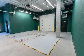 A large empty room with a white floor and green walls.